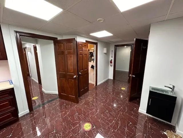 Corridor featuring a paneled ceiling Corridor featuring a paneled ceiling