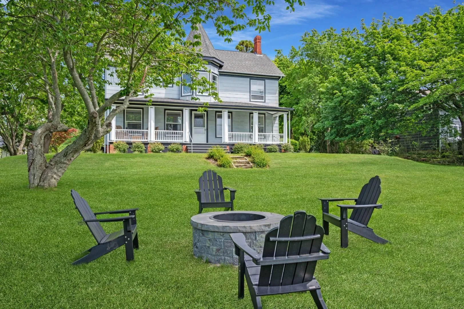 View of front of property with a fire pit, a front lawn, and covered porch View of front of property with a fire pit, a front lawn, and covered porch