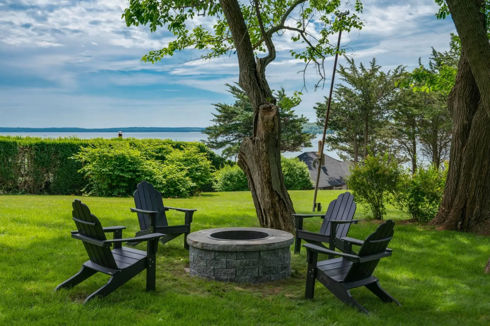 View of yard featuring a fire pit and a water view View of yard featuring a fire pit and a water view