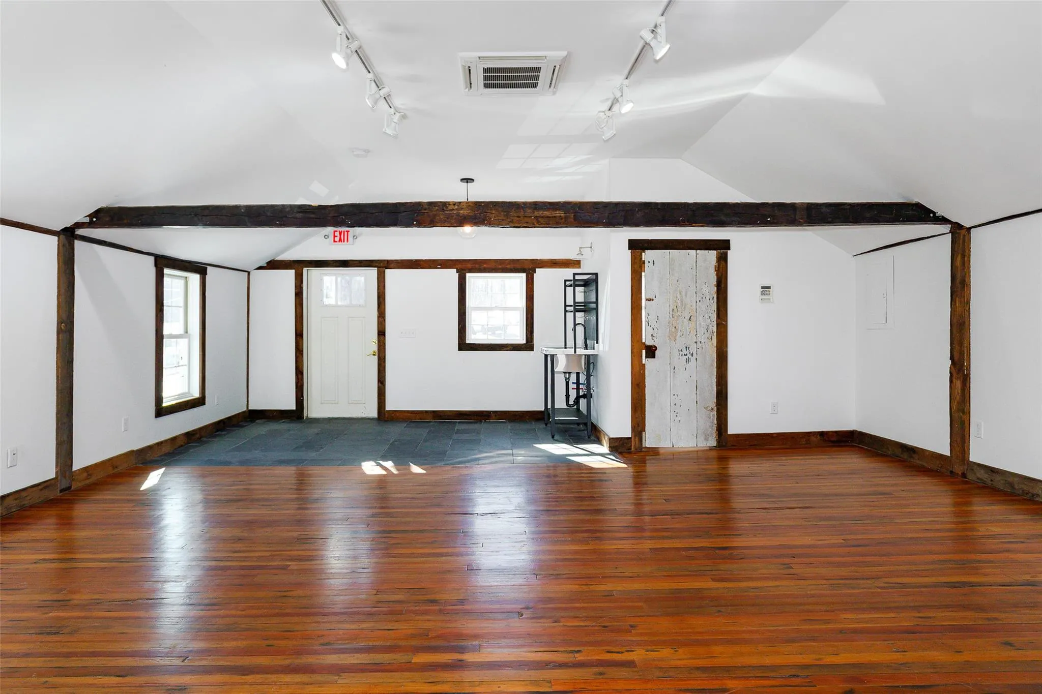 Additional living space featuring vaulted ceiling, a healthy amount of sunlight, and dark hardwood / wood-style flooring Additional living space featuring vaulted ceiling, a healthy amount of sunlight, and dark hardwood / wood-style flooring