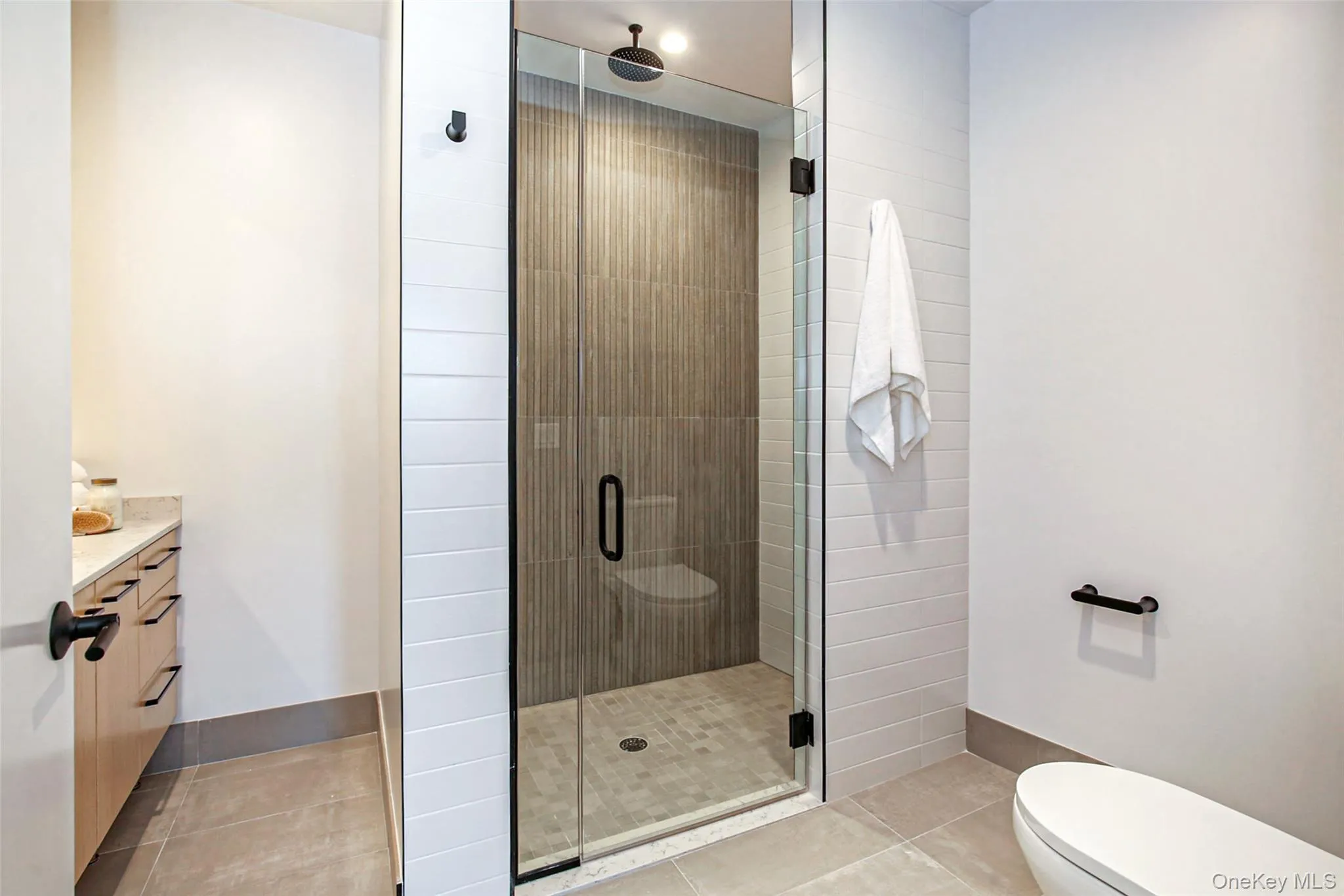 Bathroom featuring vanity, an enclosed shower, tile patterned floors, and toilet Bathroom featuring vanity, an enclosed shower, tile patterned floors, and toilet