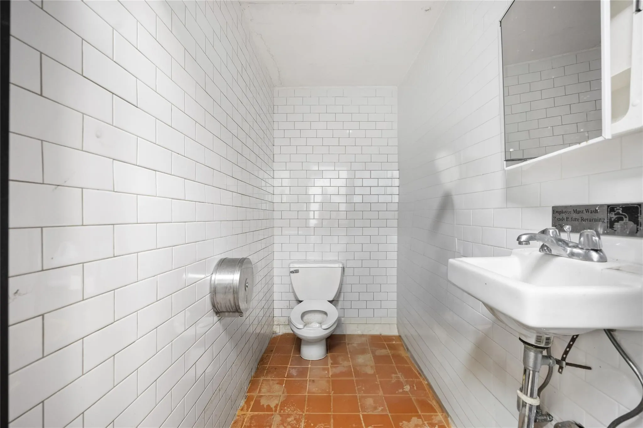 Bathroom featuring tile patterned floors, toilet, and tile walls Bathroom featuring tile patterned floors, toilet, and tile walls