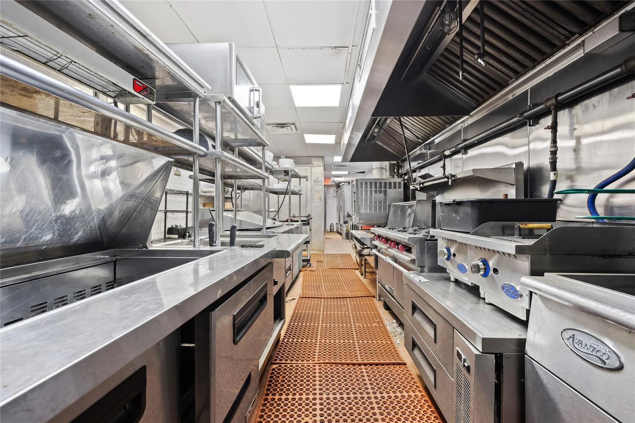 Kitchen featuring tile patterned flooring, stainless steel counters, and a drop ceiling Kitchen featuring tile patterned flooring, stainless steel counters, and a drop ceiling