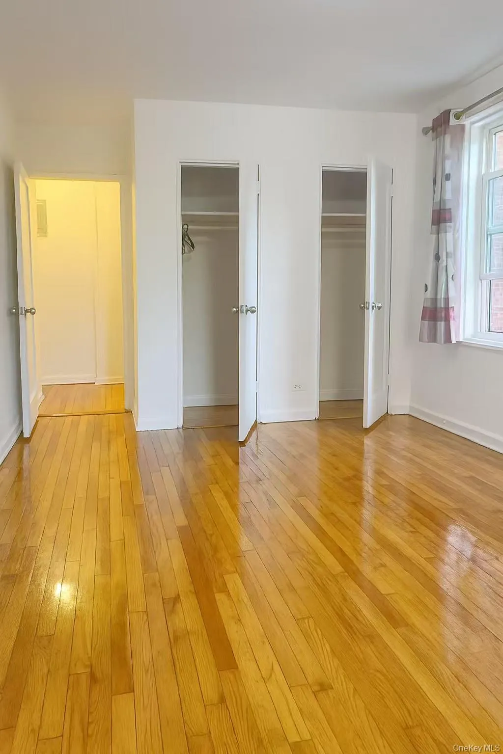 Unfurnished bedroom with multiple closets and light wood-style floors Unfurnished bedroom with multiple closets and light wood-style floors