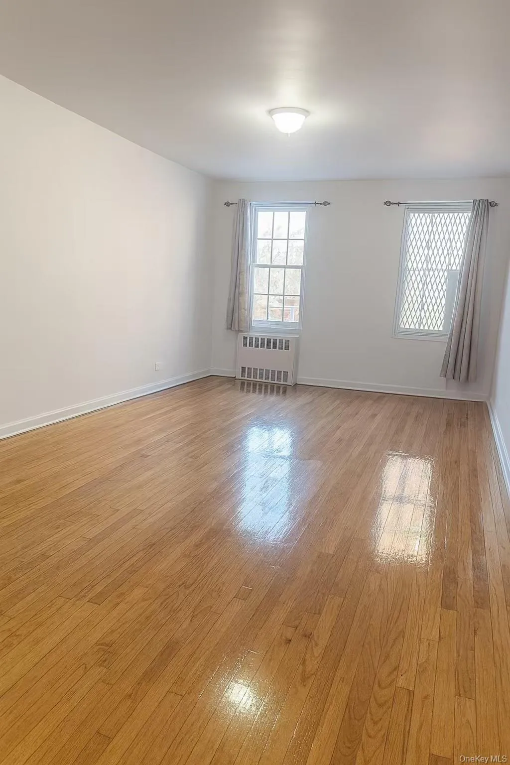 Spare room with radiator heating unit and light wood-type flooring Spare room with radiator heating unit and light wood-type flooring