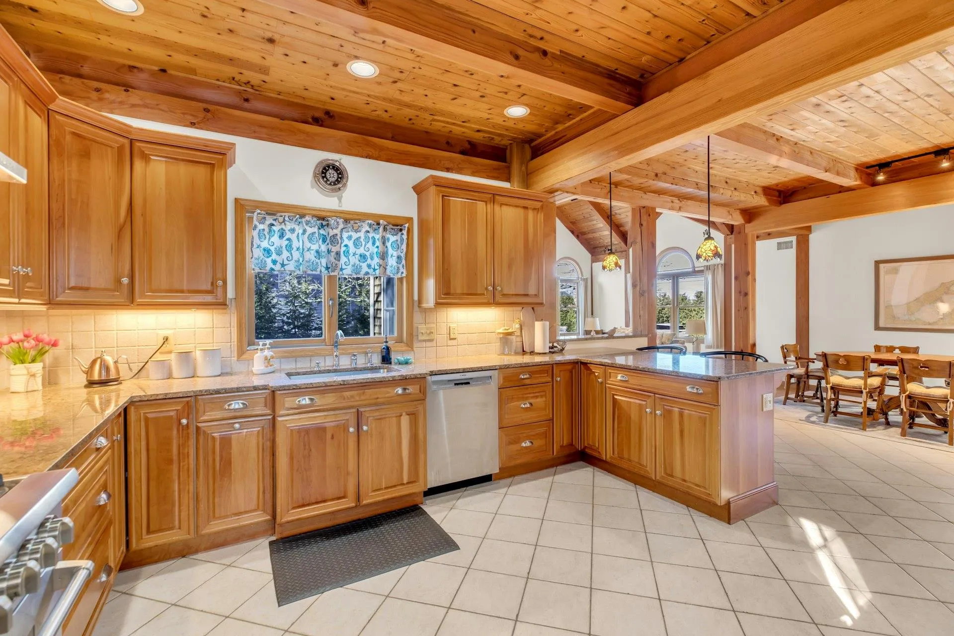 Kitchen with sink, stainless steel appliances, light stone counters, decorative light fixtures, and kitchen peninsula Kitchen with sink, stainless steel appliances, light stone counters, decorative light fixtures, and kitchen peninsula