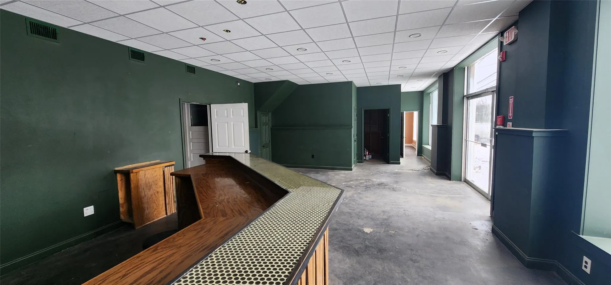 Hall with a paneled ceiling and concrete floors Hall with a paneled ceiling and concrete floors