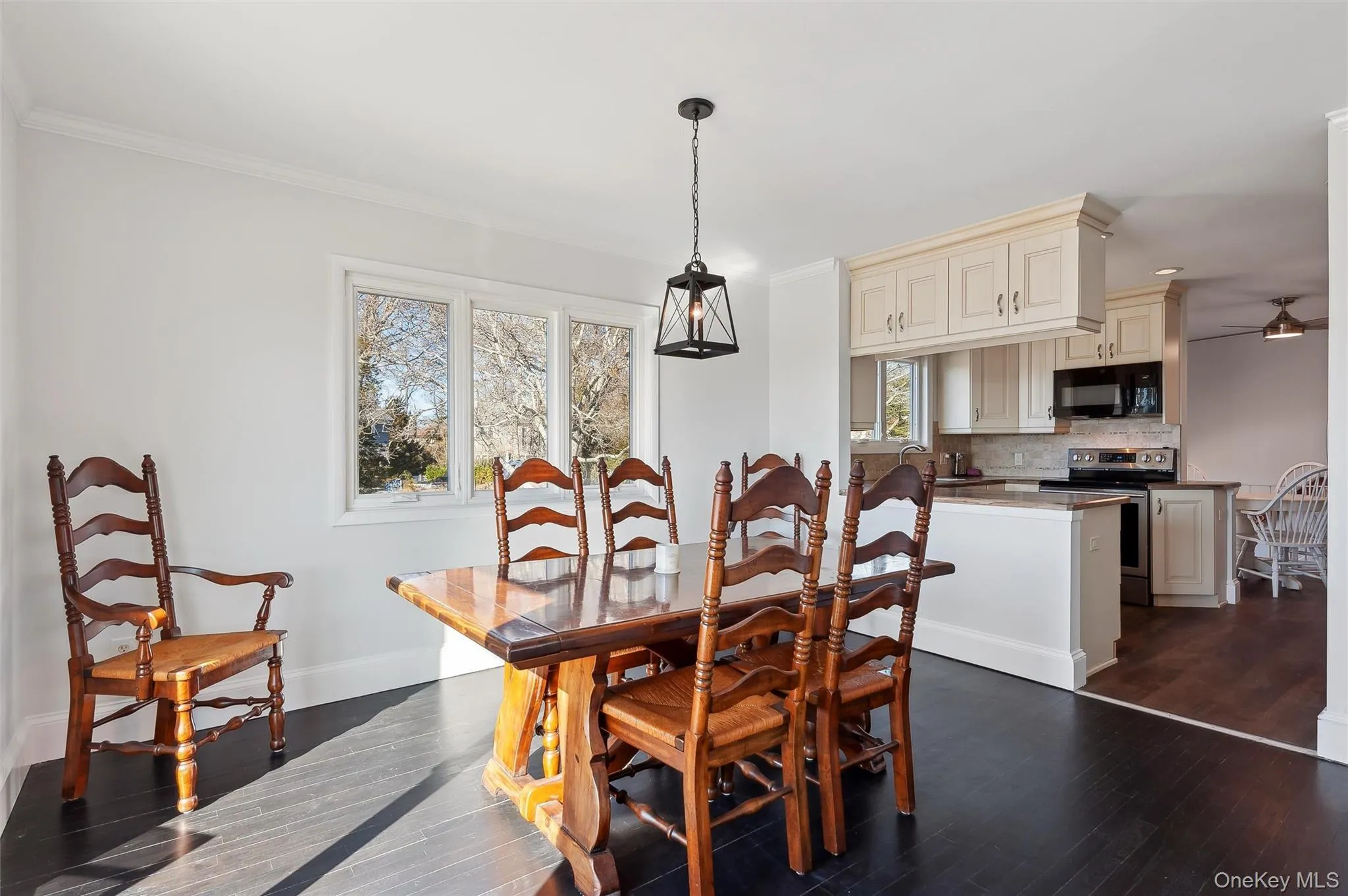 Dining area featuring ornamental molding, dark hardwood / wood-style floors, and ceiling fan Dining area featuring ornamental molding, dark hardwood / wood-style floors, and ceiling fan