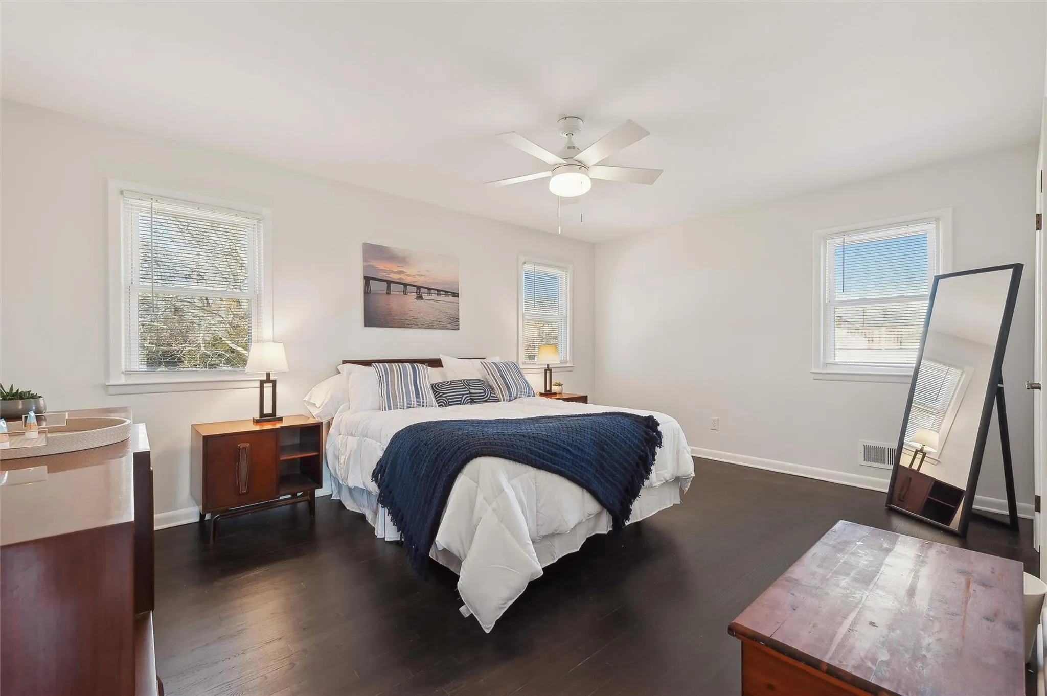 Bedroom with multiple windows, ceiling fan, and dark hardwood / wood-style flooring Bedroom with multiple windows, ceiling fan, and dark hardwood / wood-style flooring