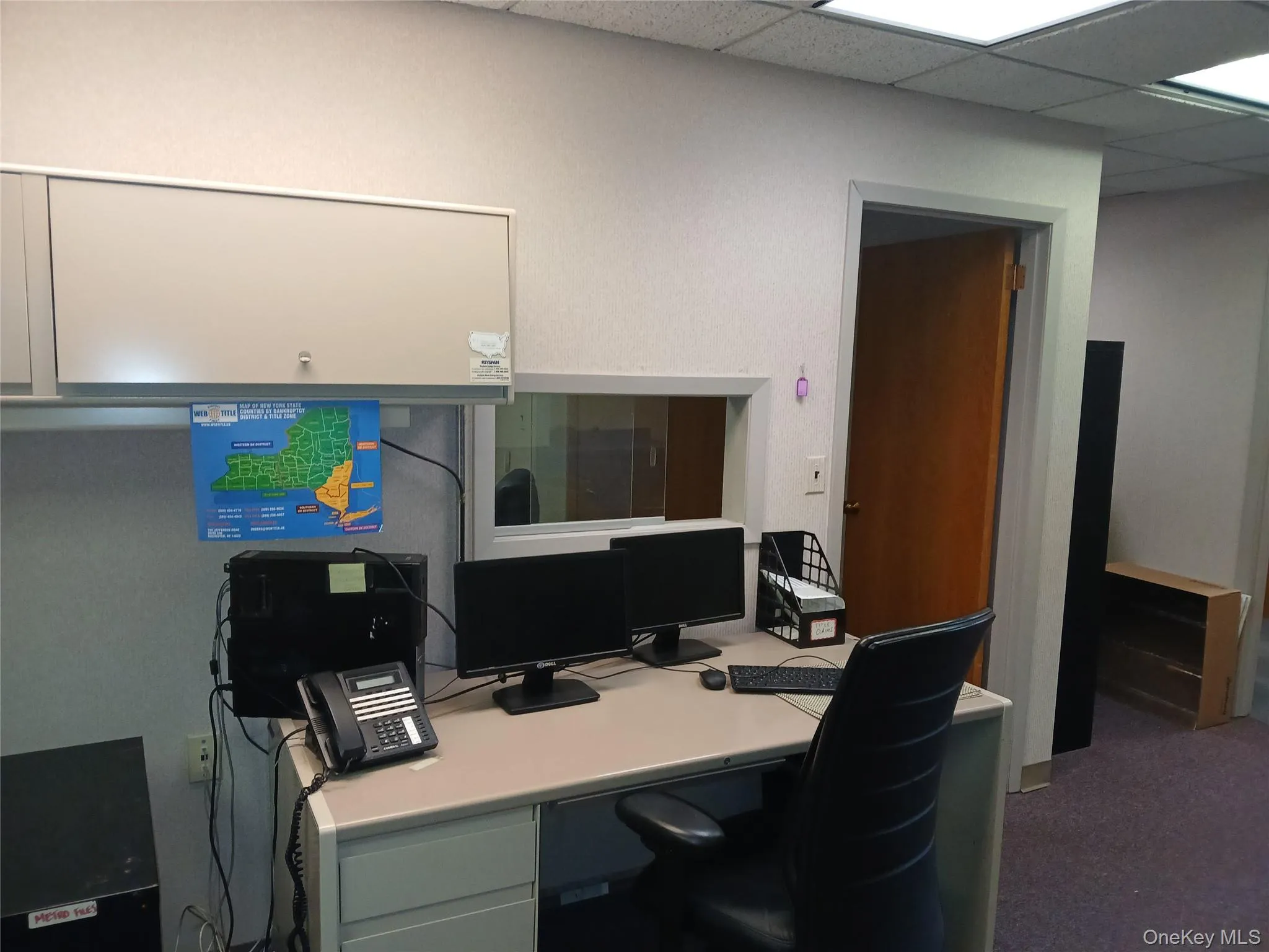 Office area with a paneled ceiling and carpet flooring Office area with a paneled ceiling and carpet flooring