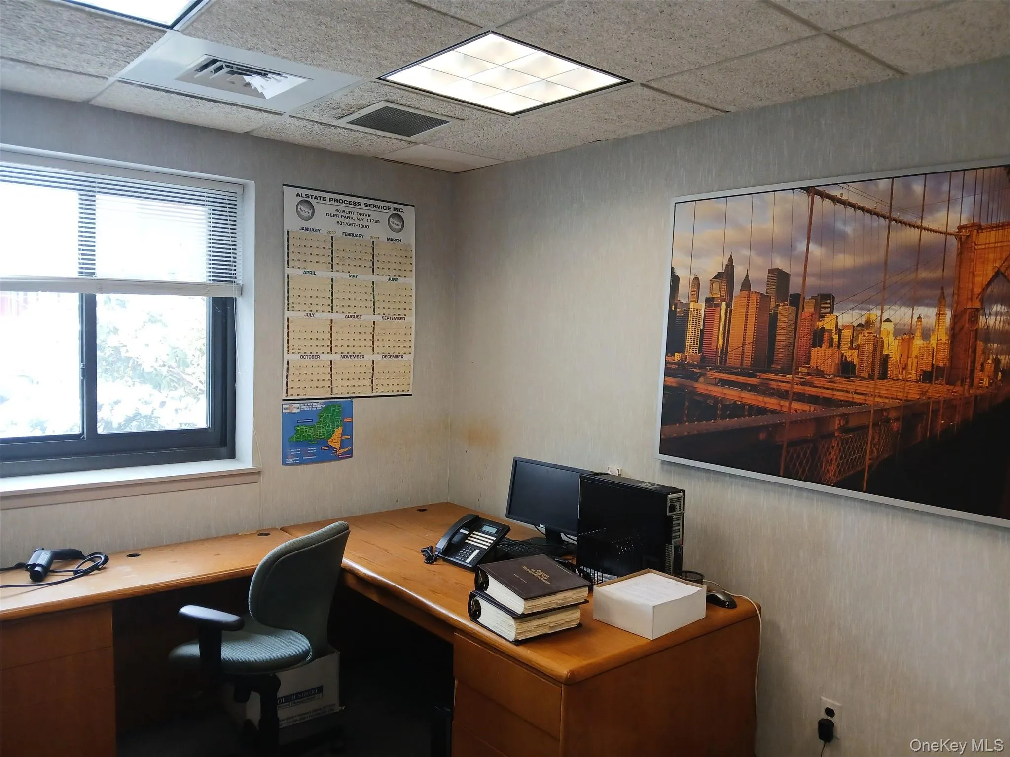 Office area with a drop ceiling and built in desk Office area with a drop ceiling and built in desk