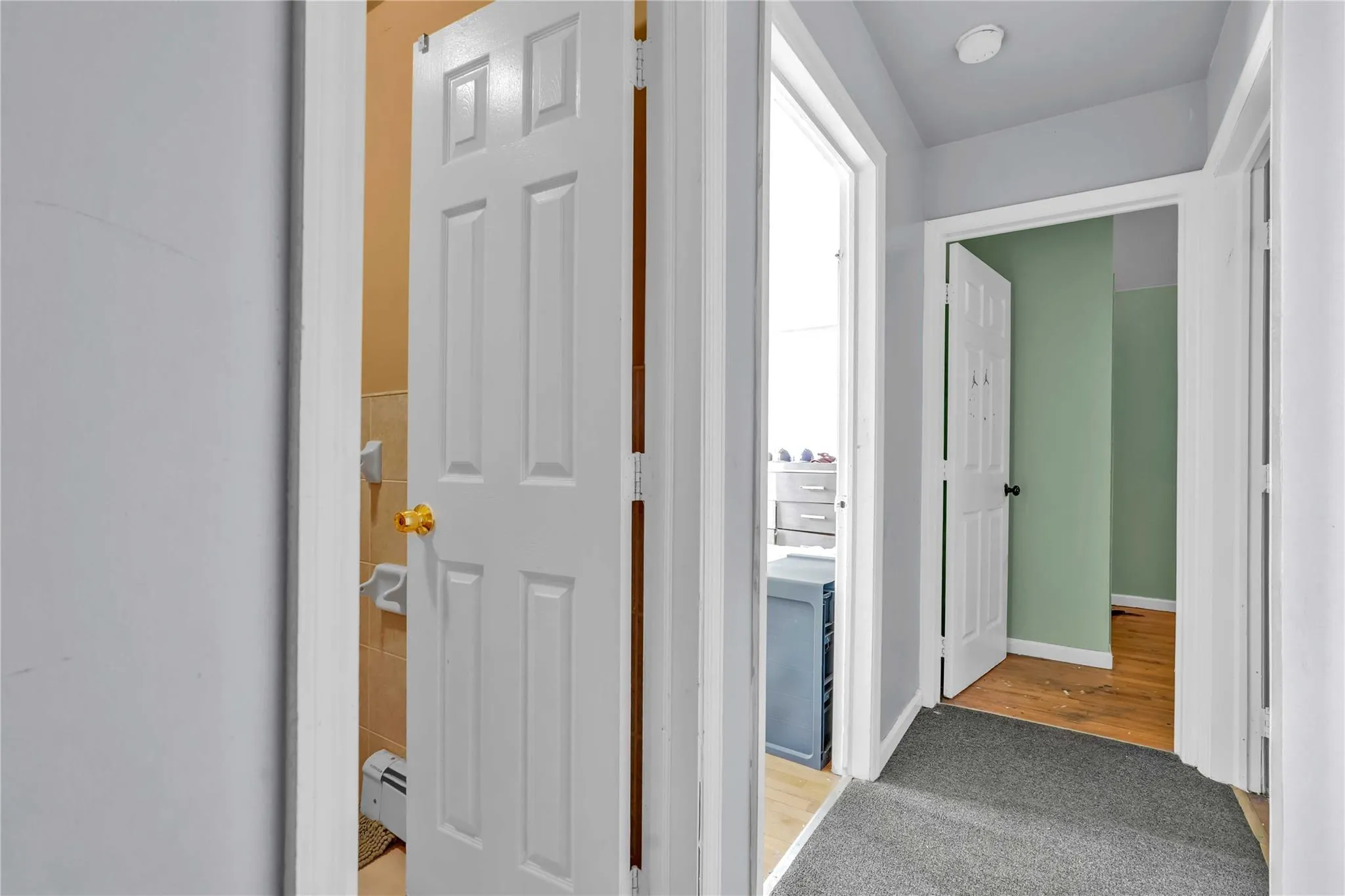 Hall featuring light carpet and baseboard heating Hall featuring light carpet and baseboard heating