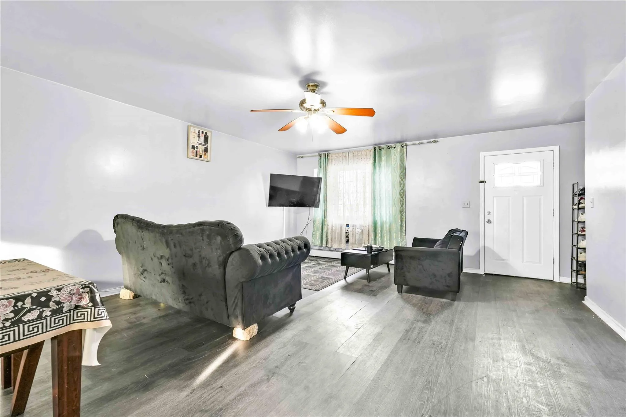 Living room featuring hardwood / wood-style flooring, plenty of natural light, and ceiling fan Living room featuring hardwood / wood-style flooring, plenty of natural light, and ceiling fan