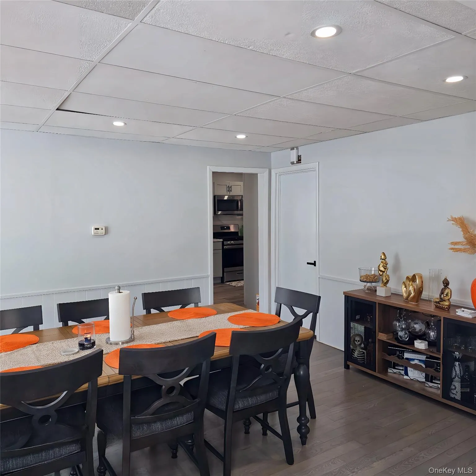 Dining space with dark wood-style floors, a paneled ceiling, and recessed lighting Dining space with dark wood-style floors, a paneled ceiling, and recessed lighting