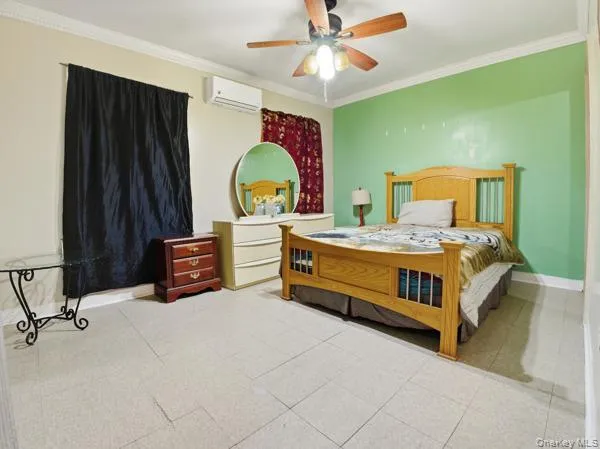 Bedroom featuring crown molding, a ceiling fan, and a wall mounted air conditioner Bedroom featuring crown molding, a ceiling fan, and a wall mounted air conditioner