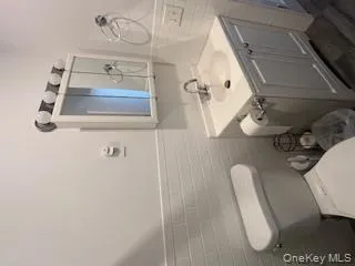 Bathroom featuring a wainscoted wall, tile walls, toilet, and vanity Bathroom featuring a wainscoted wall, tile walls, toilet, and vanity