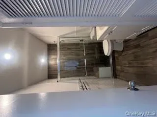 Full bath featuring tile walls, toilet, vanity, a shower stall, and wood finished floors Full bath featuring tile walls, toilet, vanity, a shower stall, and wood finished floors