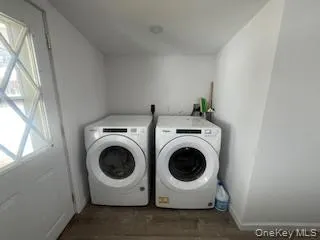Laundry area with laundry area, washer and clothes dryer, baseboards, and wood finished floors Laundry area with laundry area, washer and clothes dryer, baseboards, and wood finished floors