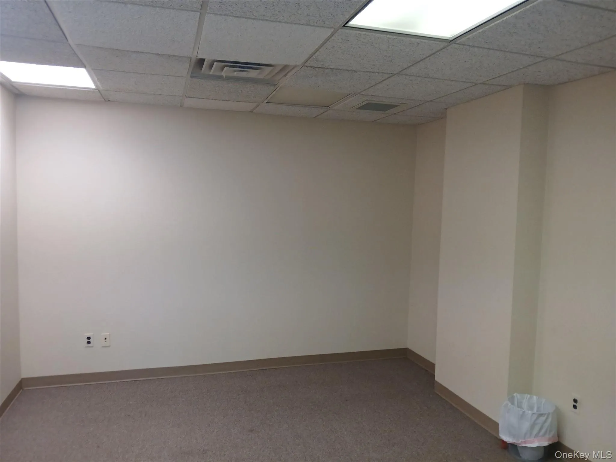 Empty room with a drop ceiling and carpet Empty room with a drop ceiling and carpet