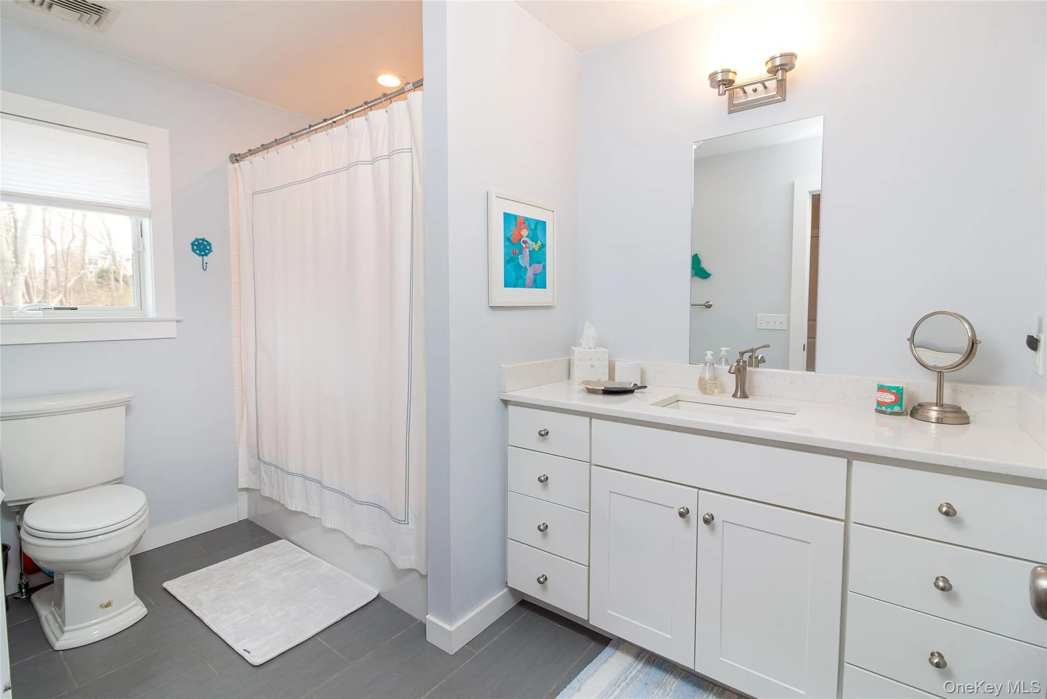 Full bathroom featuring vanity, shower / bath combination with curtain, and toilet Full bathroom featuring vanity, shower / bath combination with curtain, and toilet