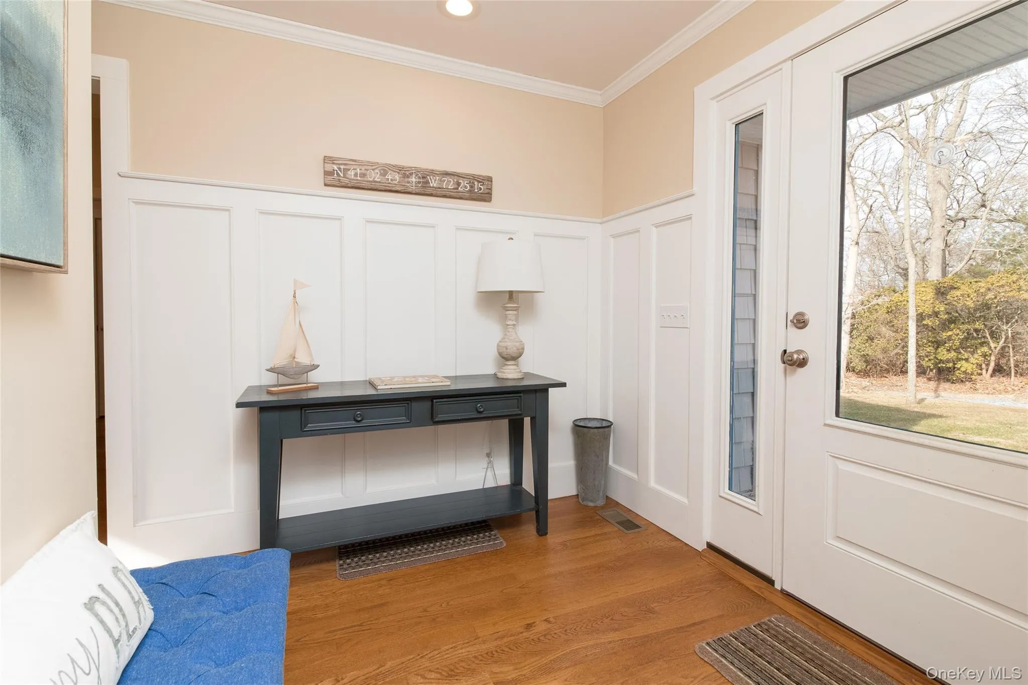 Foyer entrance with hardwood / wood-style floors, plenty of natural light, and ornamental molding Foyer entrance with hardwood / wood-style floors, plenty of natural light, and ornamental molding