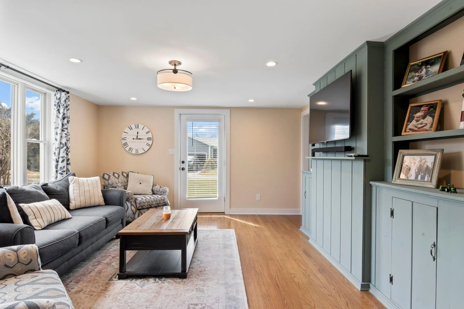 Living room with a healthy amount of sunlight and light wood-type flooring Living room with a healthy amount of sunlight and light wood-type flooring