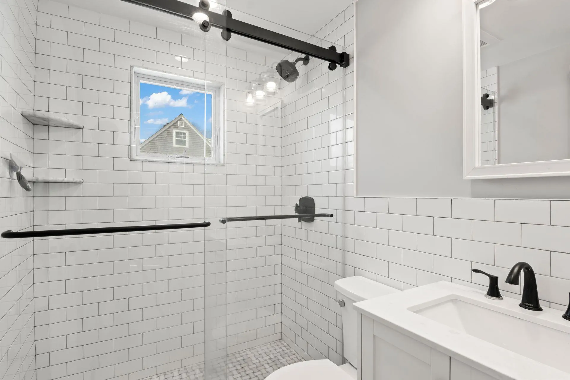 Bathroom with vanity, a shower with door, tile walls, and toilet Bathroom with vanity, a shower with door, tile walls, and toilet