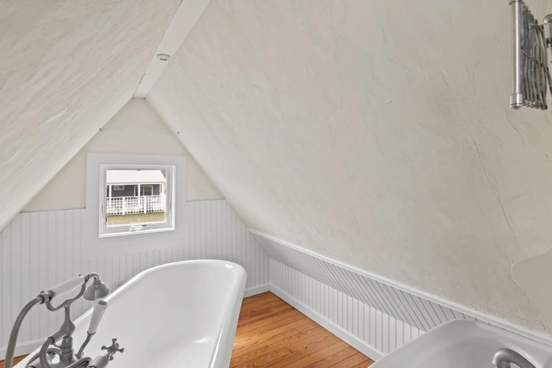 Bathroom featuring wood-type flooring, a bathing tub, and lofted ceiling Bathroom featuring wood-type flooring, a bathing tub, and lofted ceiling