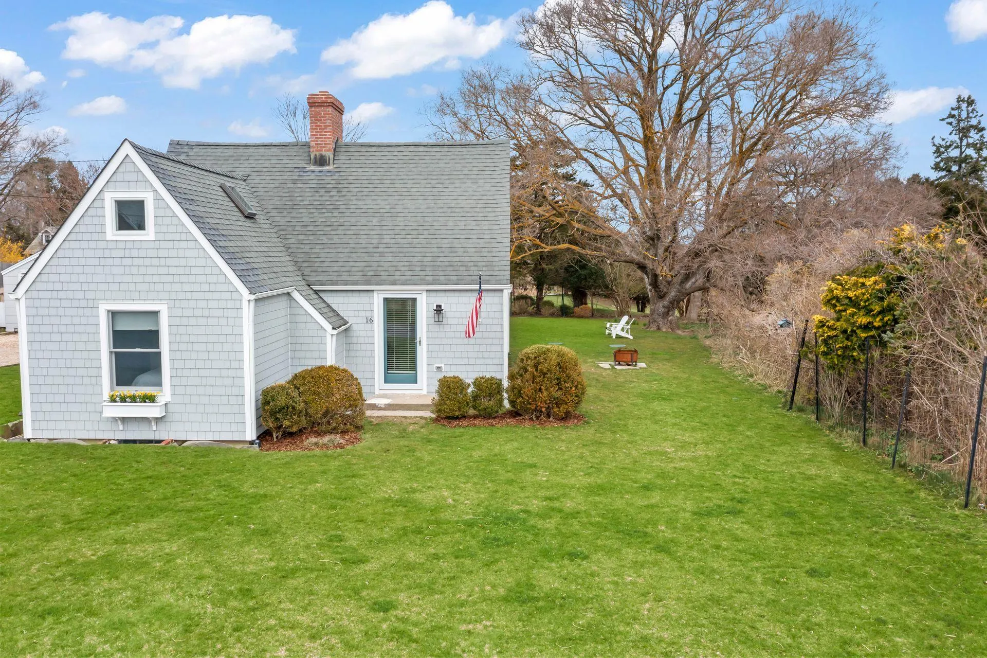 Back of property with an outdoor fire pit and a lawn Back of property with an outdoor fire pit and a lawn