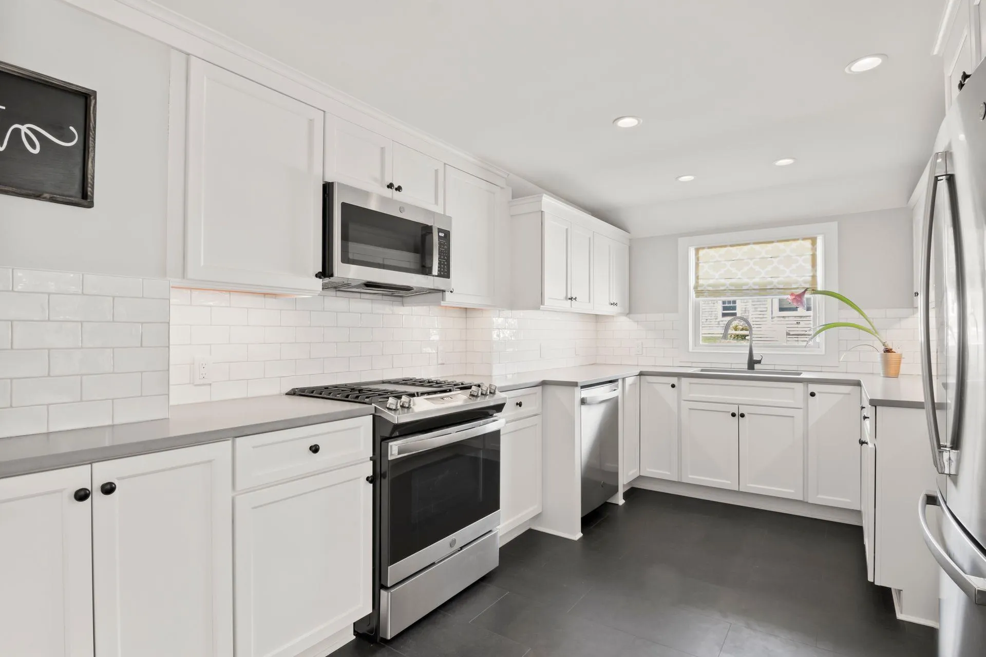 Kitchen featuring white cabinetry, stainless steel appliances, sink, and tasteful backsplash Kitchen featuring white cabinetry, stainless steel appliances, sink, and tasteful backsplash