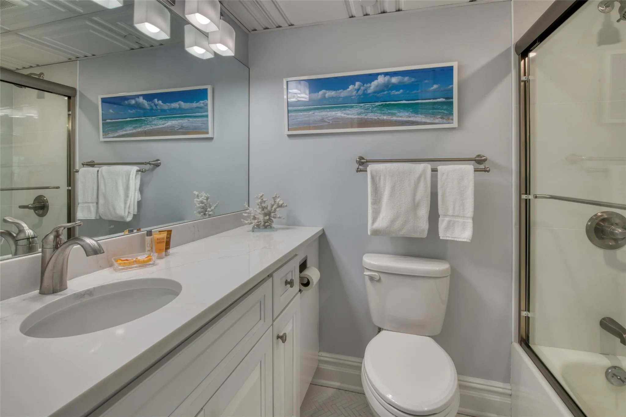 Full bathroom with vanity, shower / bath combination with glass door, and toilet Full bathroom with vanity, shower / bath combination with glass door, and toilet