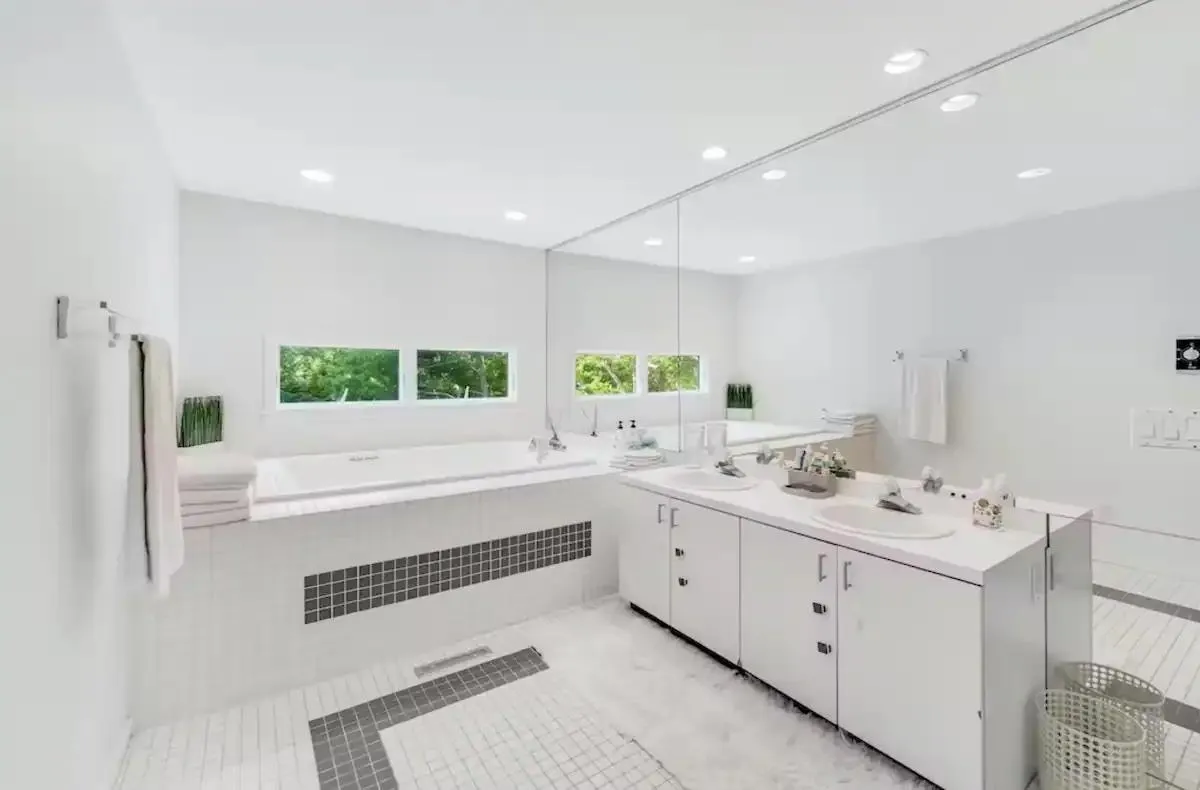 Bathroom featuring tile patterned floors, vanity, and tiled tub Bathroom featuring tile patterned floors, vanity, and tiled tub