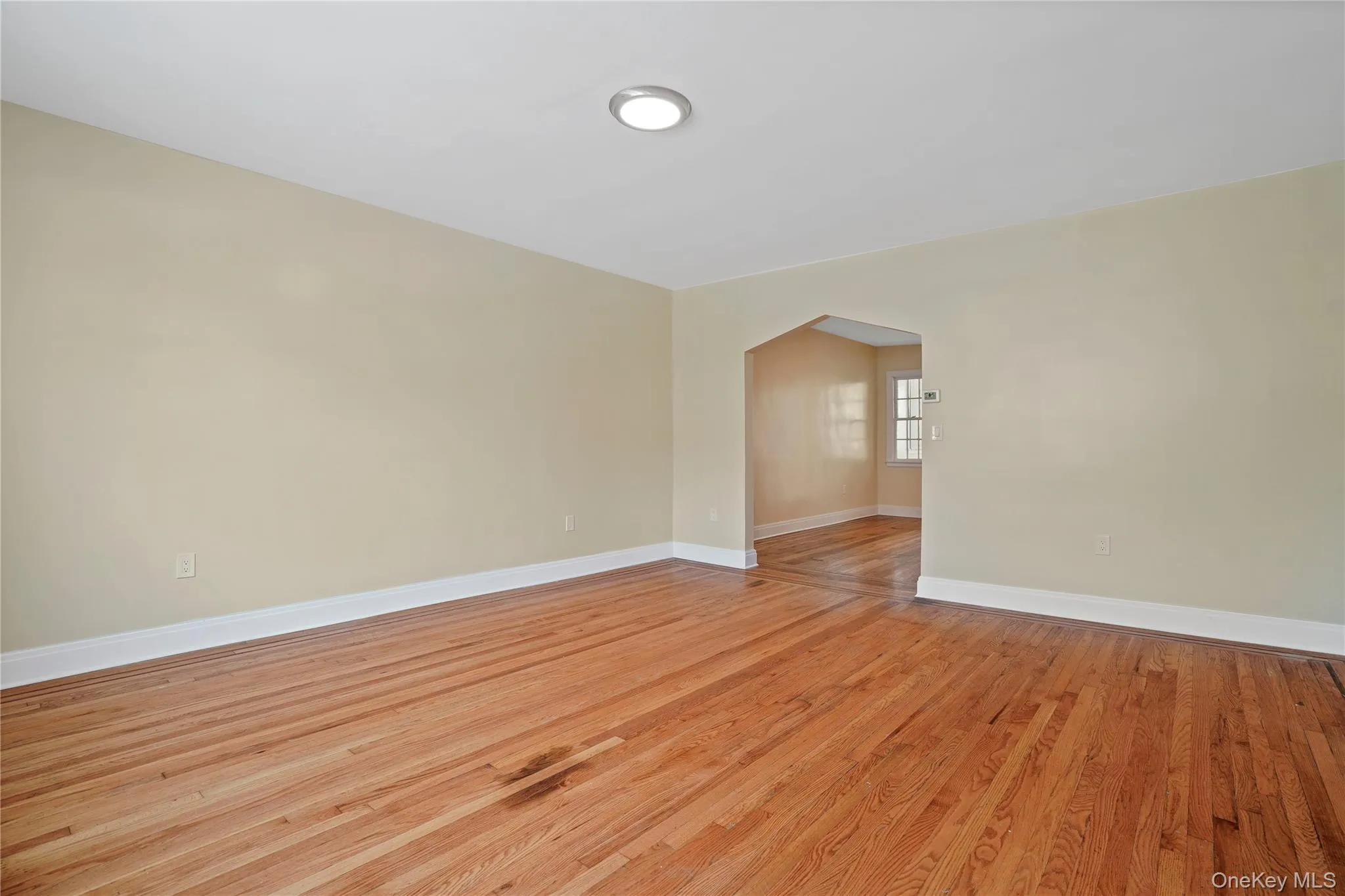 Spare room with arched walkways and light wood-style floors Spare room with arched walkways and light wood-style floors