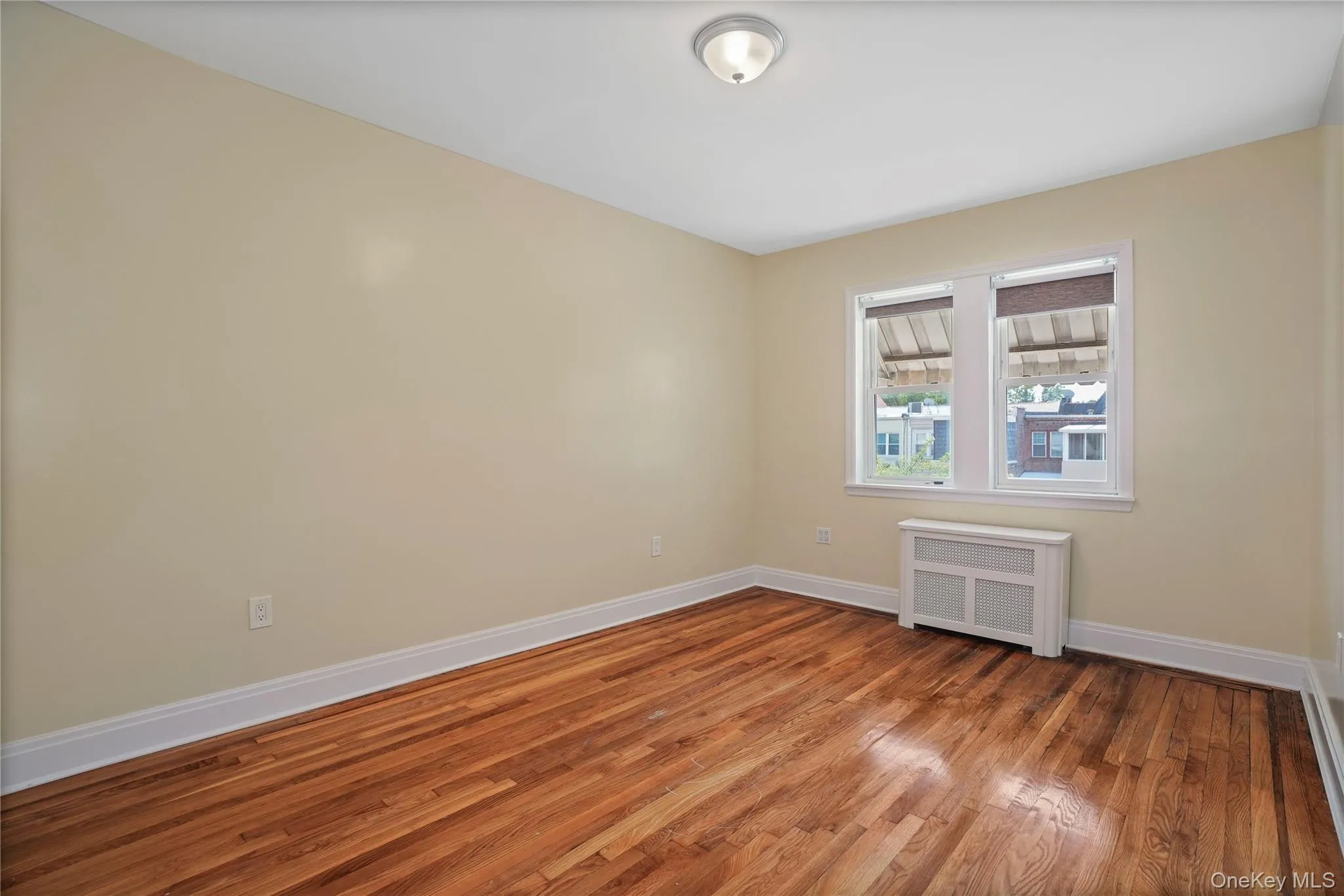 Empty room with radiator heating unit and wood finished floors Empty room with radiator heating unit and wood finished floors