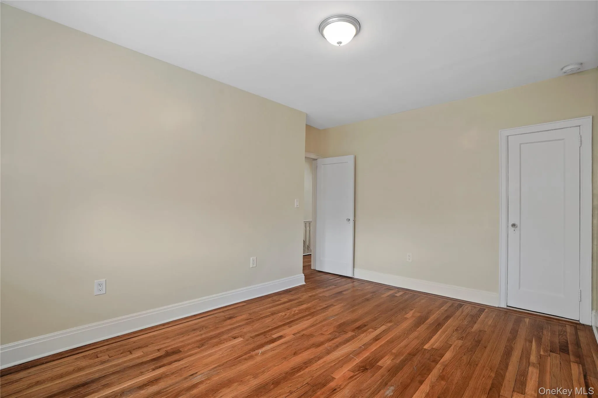 Unfurnished bedroom with wood finished floors and baseboards Unfurnished bedroom with wood finished floors and baseboards