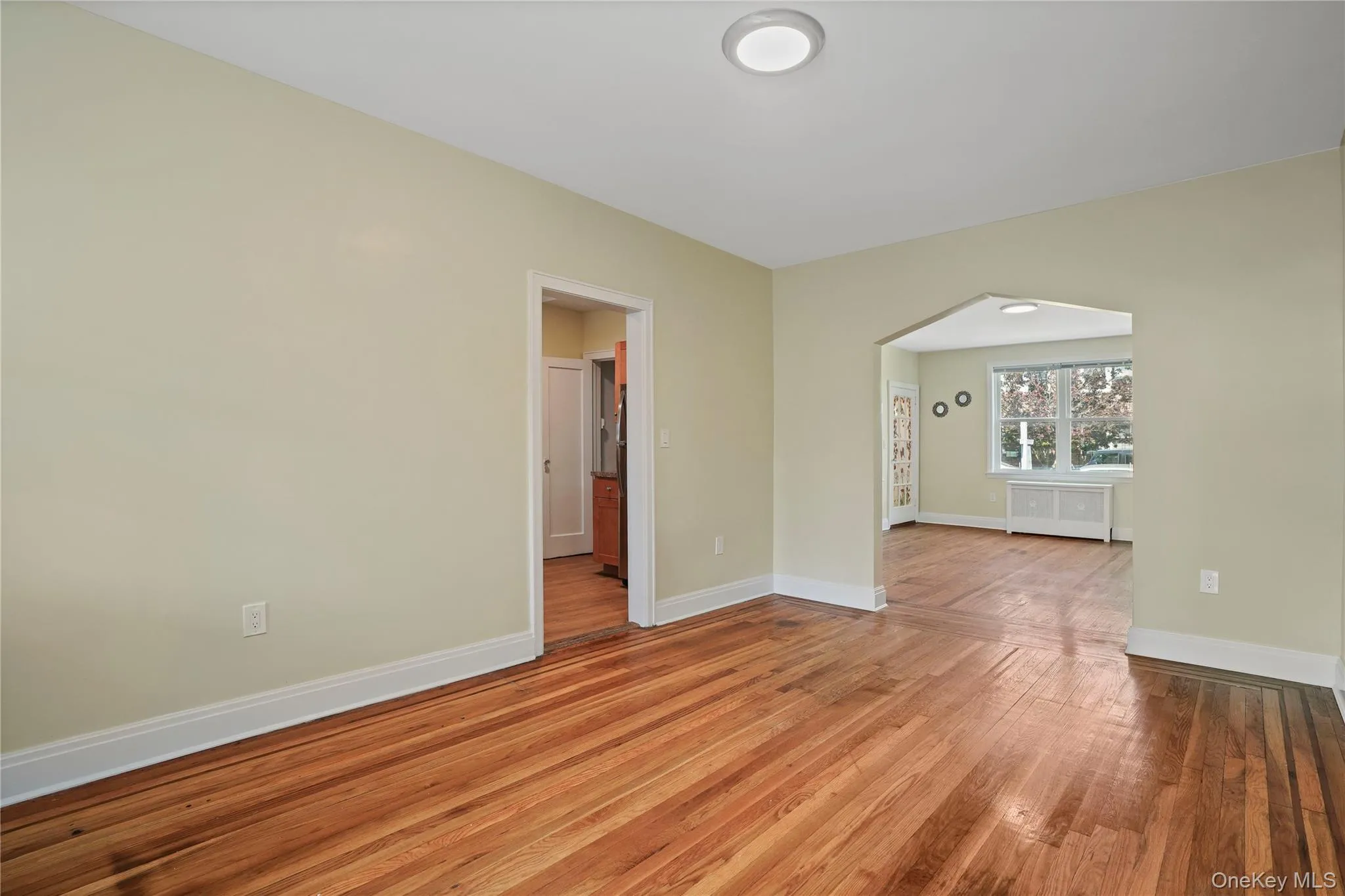 Unfurnished room with wood finished floors and radiator heating unit Unfurnished room with wood finished floors and radiator heating unit