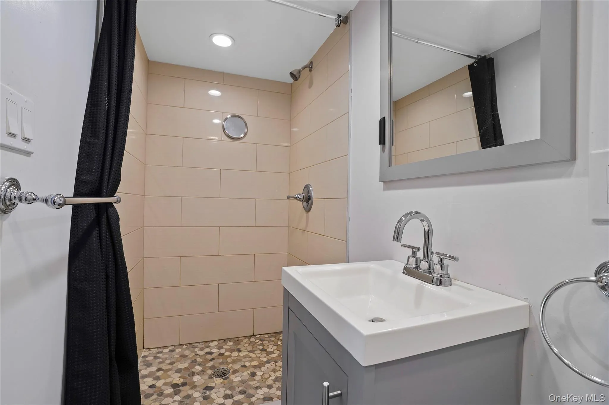 Bathroom with a tile shower, vanity, and recessed lighting Bathroom with a tile shower, vanity, and recessed lighting