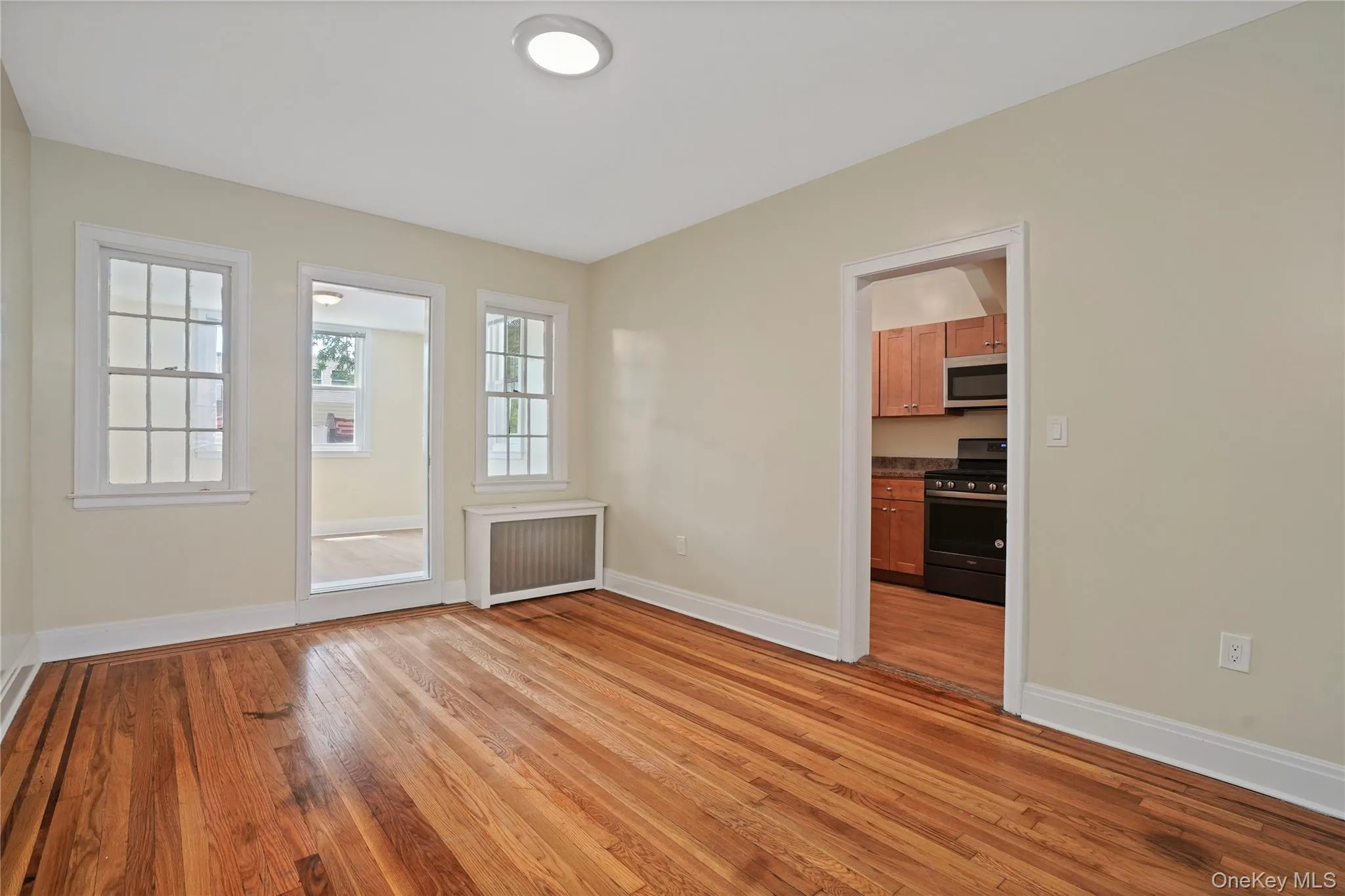 Spare room featuring radiator and light wood-style floors Spare room featuring radiator and light wood-style floors