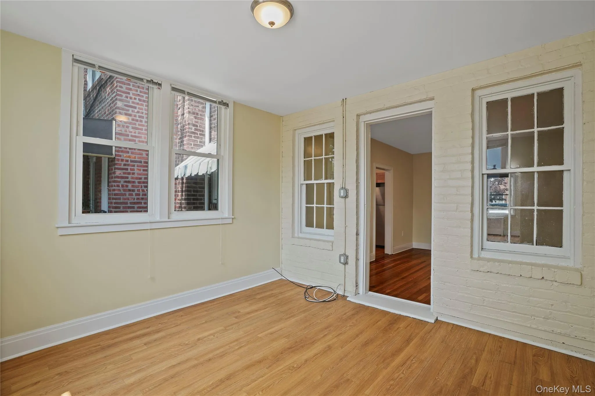 Spare room with wood finished floors and brick wall Spare room with wood finished floors and brick wall