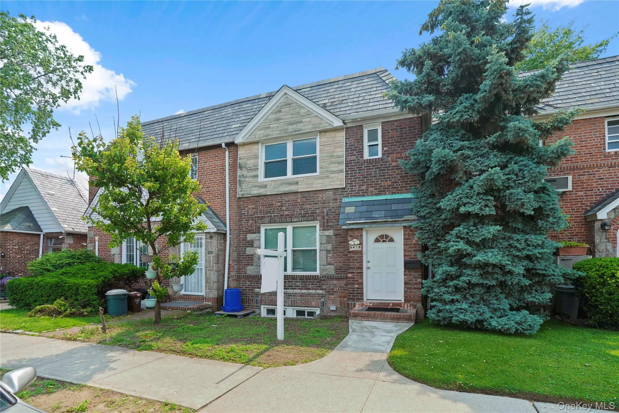 Multi unit property with a high end roof, brick siding, and a front lawn Multi unit property with a high end roof, brick siding, and a front lawn