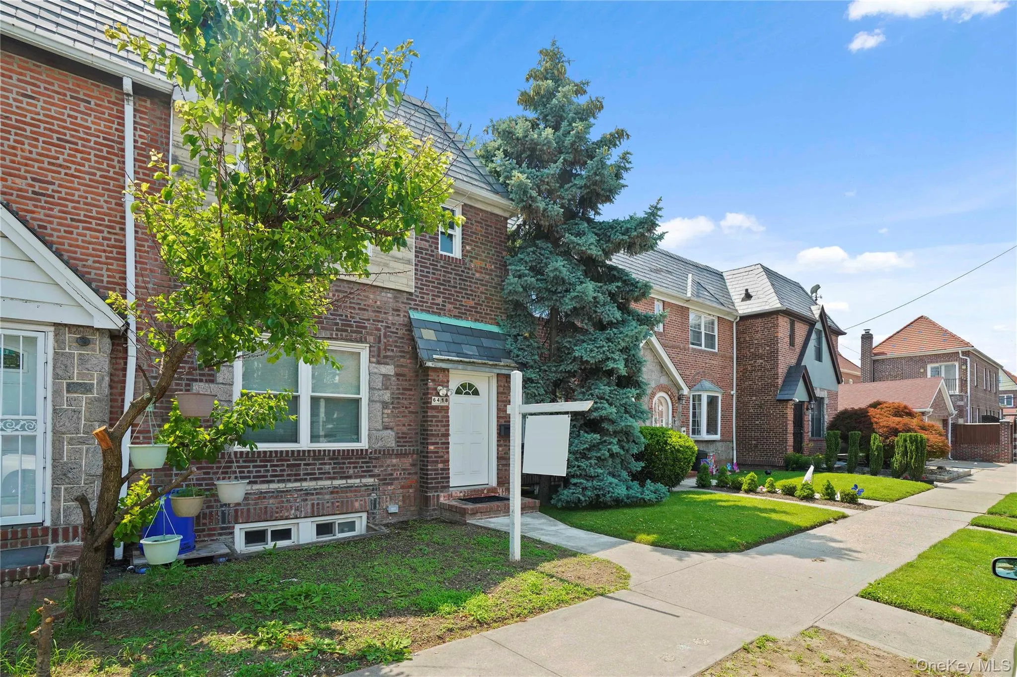 View of front of house with a front lawn, entry steps, brick siding, a high end roof, and a residential view View of front of house with a front lawn, entry steps, brick siding, a high end roof, and a residential view