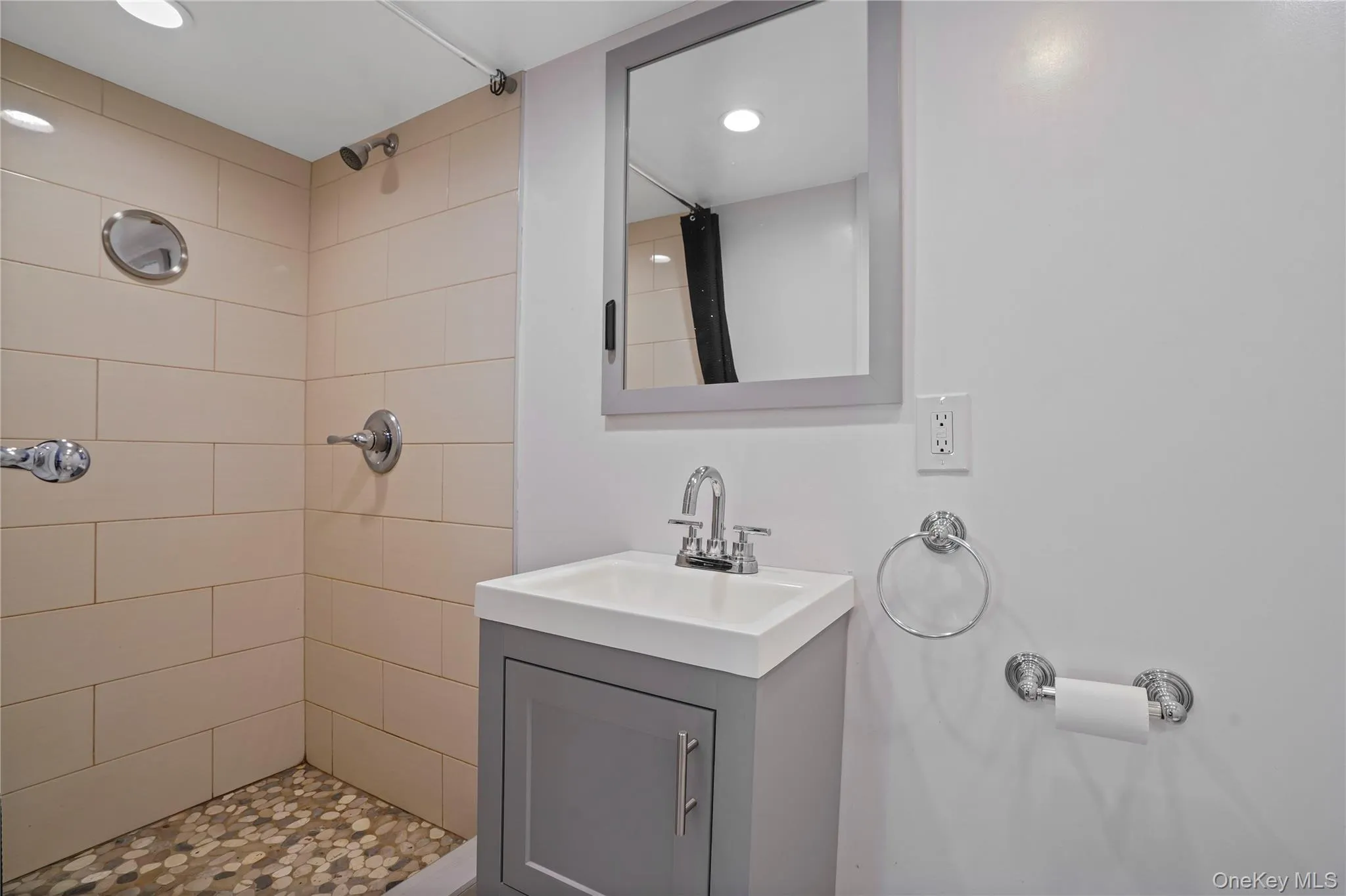 Bathroom with tiled shower, vanity, and recessed lighting Bathroom with tiled shower, vanity, and recessed lighting
