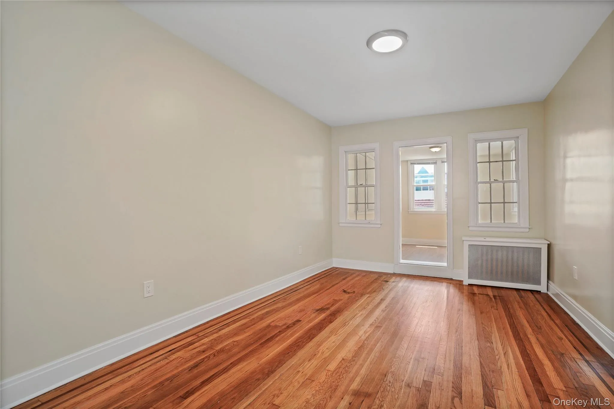 Spare room with radiator heating unit and hardwood / wood-style floors Spare room with radiator heating unit and hardwood / wood-style floors