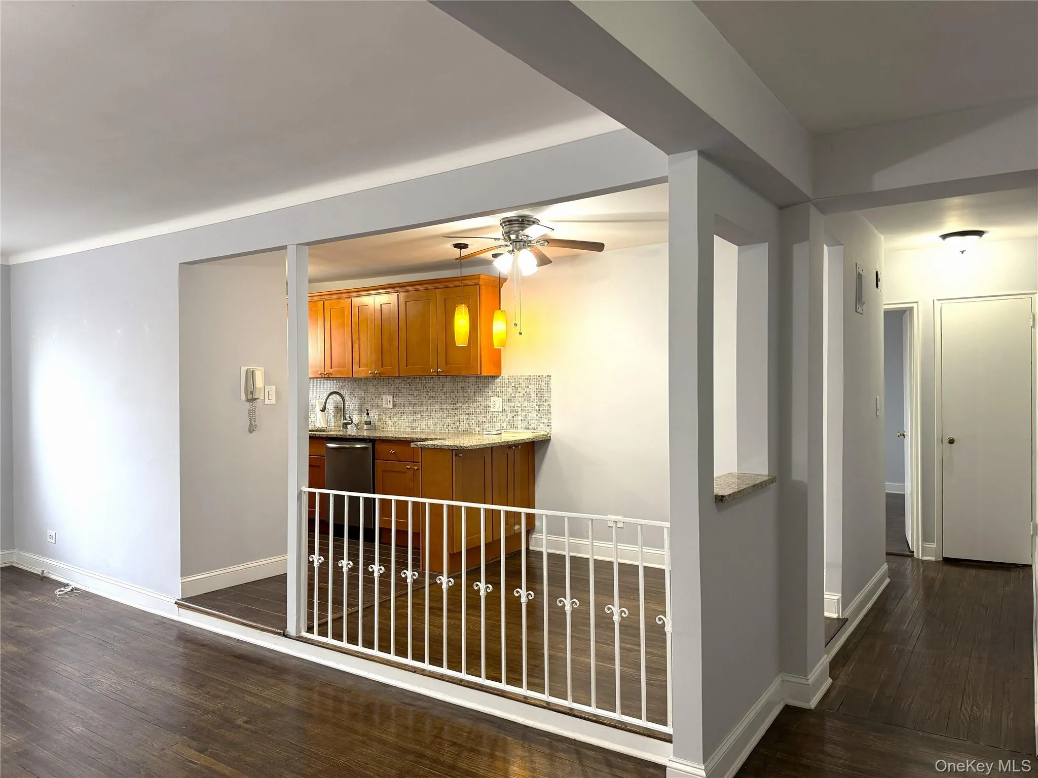 Kitchen featuring ceiling fan, dark hardwood / wood-style flooring, dishwasher, and backsplash Kitchen featuring ceiling fan, dark hardwood / wood-style flooring, dishwasher, and backsplash