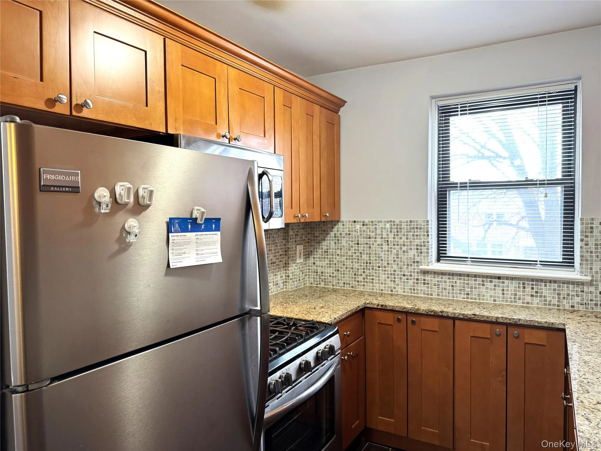 Kitchen featuring light stone counters, tasteful backsplash, and appliances with stainless steel finishes Kitchen featuring light stone counters, tasteful backsplash, and appliances with stainless steel finishes
