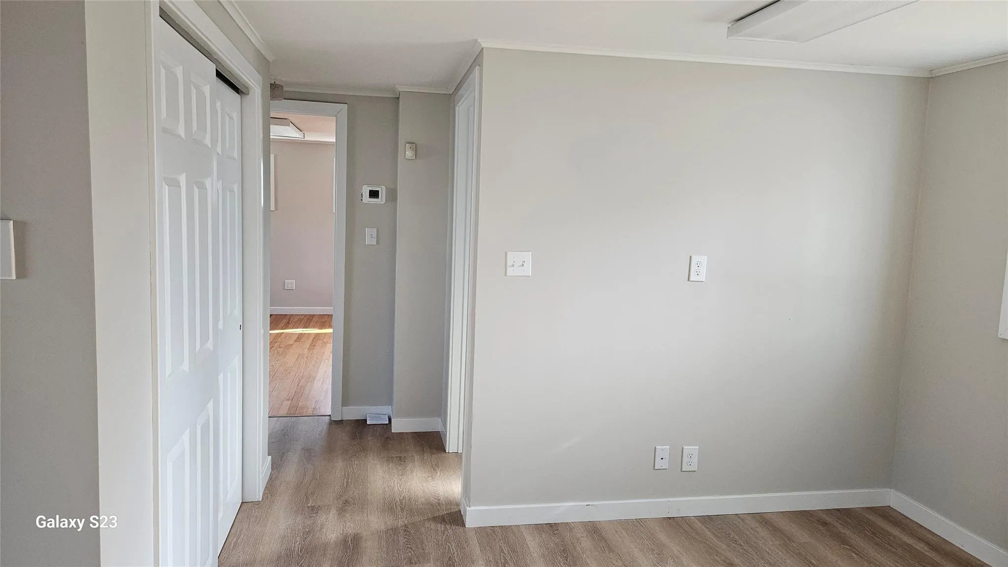 Hallway with ornamental molding and light wood-type flooring Hallway with ornamental molding and light wood-type flooring