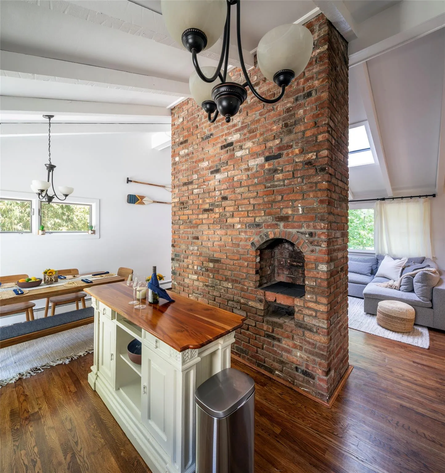 Kitchen featuring butcher block counters, vaulted ceiling with beams, dark hardwood / wood-style flooring, a chandelier, and hanging light fixtures Kitchen featuring butcher block counters, vaulted ceiling with beams, dark hardwood / wood-style flooring, a chandelier, and hanging light fixtures