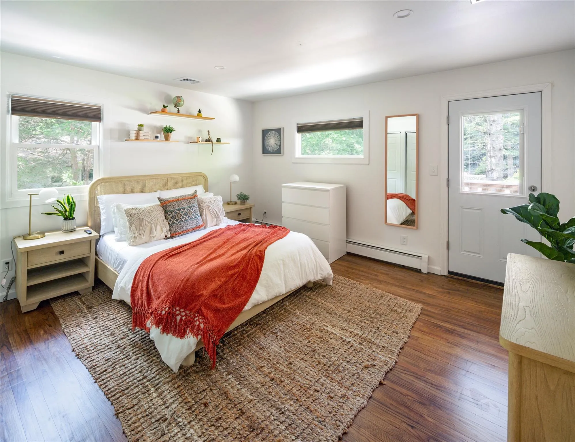 Bedroom with multiple windows, a baseboard heating unit, and dark hardwood / wood-style floors Bedroom with multiple windows, a baseboard heating unit, and dark hardwood / wood-style floors