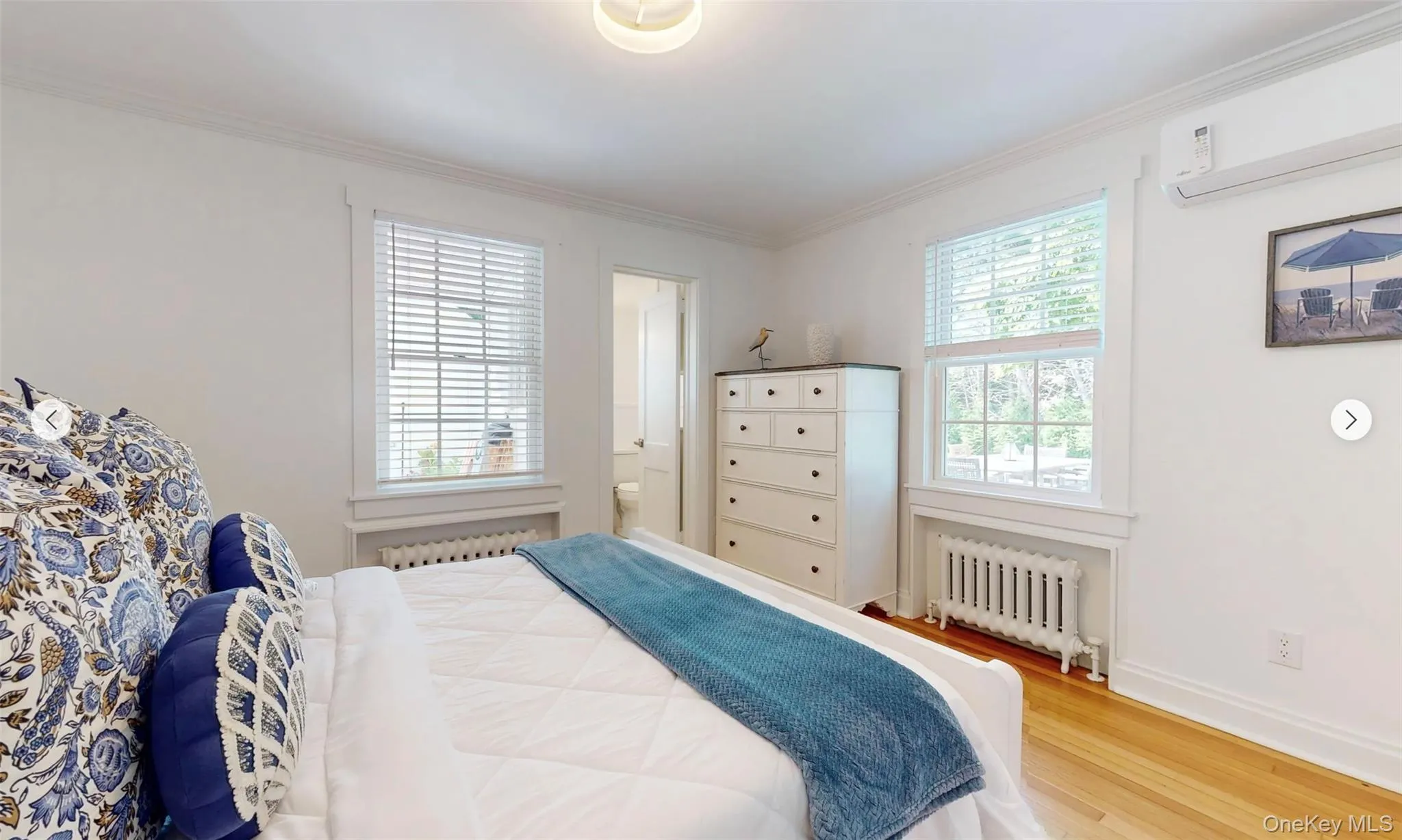 Bedroom with wood-type flooring, radiator heating unit, ensuite bathroom, and crown molding Bedroom with wood-type flooring, radiator heating unit, ensuite bathroom, and crown molding