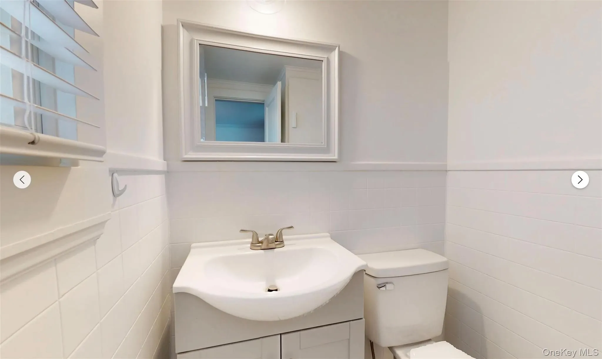 Bathroom featuring vanity, tile walls, and toilet Bathroom featuring vanity, tile walls, and toilet